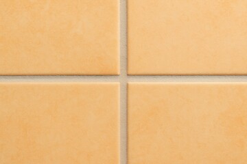 Fototapeta premium Close-up of ceramic floor tiles in warm neutral tones, showcasing the texture and grout lines, ideal for backgrounds and design elements in interior projects.