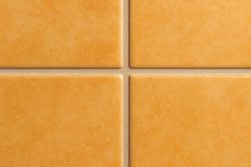 Fototapeta premium Close-up of four square orange tiles with beige grout lines forming a symmetrical design, ideal for background textures and seamless patterns in architectural design.