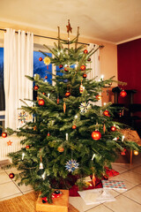 Festive Decorated Christmas Tree in a Cozy Living Room at Twilight, Warm Glowing Ornaments in Natural Evening Light