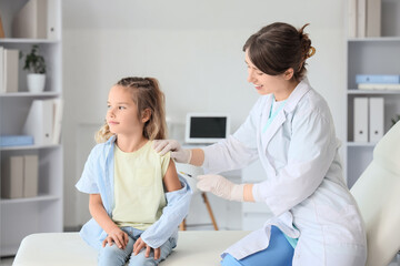 Obraz premium Female doctor vaccinating little girl in clinic