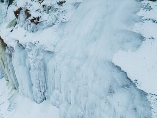 Massive frozen ice wall on the limestone cliffs of Paldiski, Estonia, featuring intricate icicles and snow-covered coastal rock formations in winter.