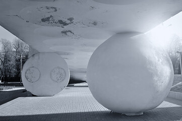 Architecture complex in futuristic style - concrete ball and hemisphere, holding up the sloping shaped ceiling under sunlight. Modern architecture background. Black and white cold tones processing