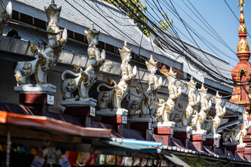Separate fragments of a decorated Buddhist temple in Thailand on a sunny day