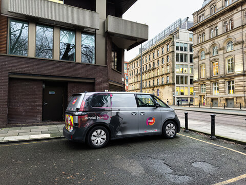 Manchester city Mitie Volkswagen ID. Buzz Cargo van for technical services in an urban street scene with modern buildings