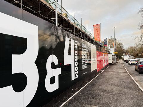 Construction site Eccleston Homes banners along a Manchester street showcase urban design and modern homes