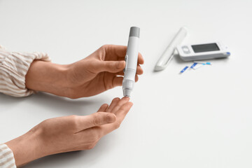 Woman using glucometer on white background