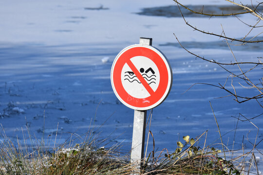 panneau interdiction de nager avec lac gel&eacute; en arri&egrave;re plan, France