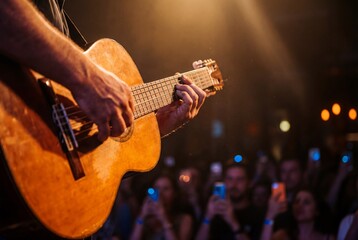 Obraz premium Close up of musician hands playing an acoustic guitar at a live concert