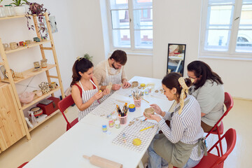Group Of Friends Making Pottery In Bright Studio During A Craft Workshop