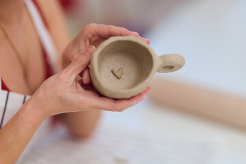Hands Holding Heart-Shaped Clay Mug in Progress &mdash; Handmade Ceramic Cup for Gift and Love
