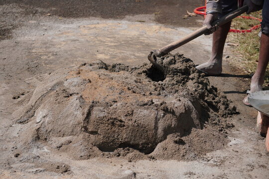 Manual Cement Mixing with Shovel on Ground