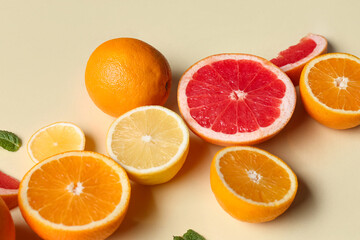 Fototapeta premium Different cut citrus fruits and mint leaves on beige background