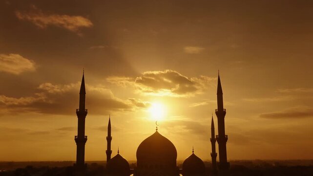 Silhouette of a mosque with minarets against a golden sunset sky, evoking a sense of peace and spiritual reflection