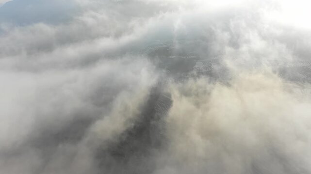 Drone flight over low hanging clouds reveals spectacular terraced rice fields in Yuanyang - famous rural landscape in China
