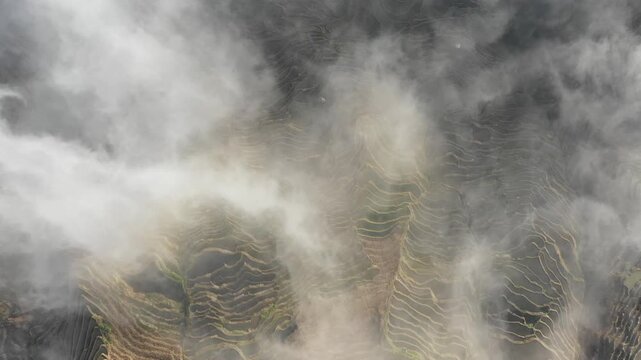 China historic irrigation system - aerial view of misty rice paddy terraces in Yuanyang