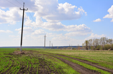 Rural Landscape with Power Lines and Dirt Track Under a Cloudy Sky copy space