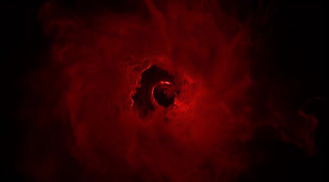 A menacing vortex of deep red cosmic dust against a black background