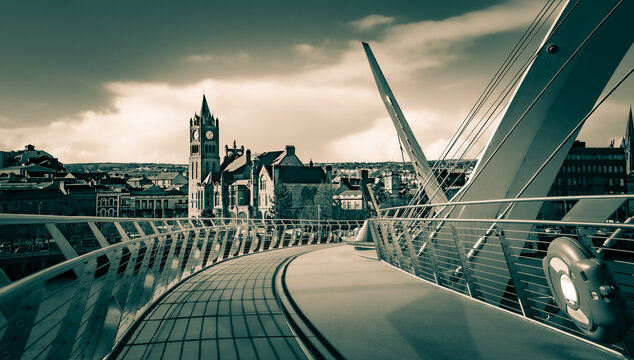 Split toned black and white view of the Guildhall in Derry, Ireland from the pedestrian Peace Bridge