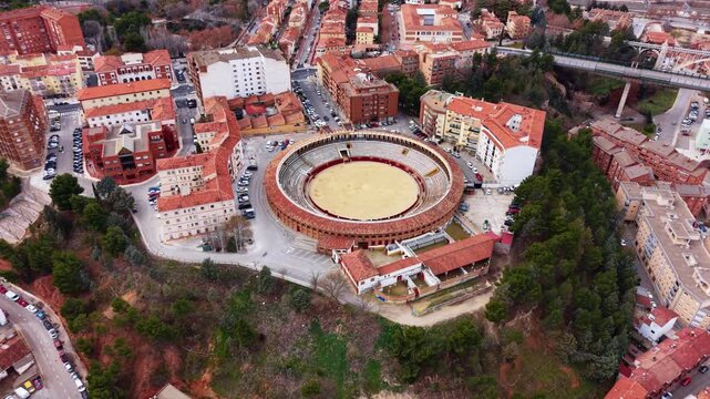 View of the historic bullring in Teruel city, showing the circular corrida stadium integrated into the dense urban fabric of Aragon, Spain