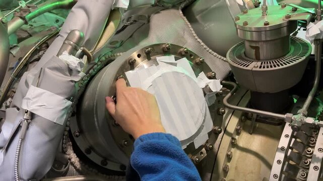 A video documenting the disassembly process of a complex gas turbine engine. The footage captures skilled technicians carefully removing complex engine components such as combustion chambers.