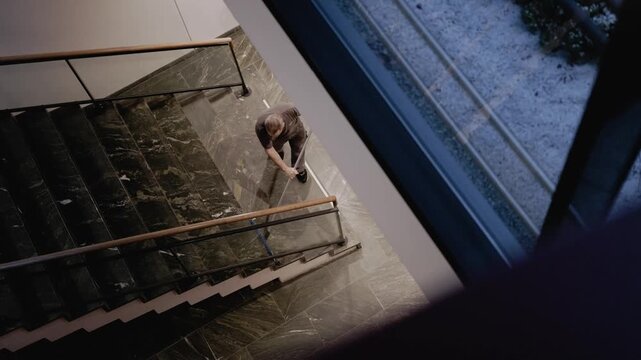 Reinigungskraft wischt die Treppe