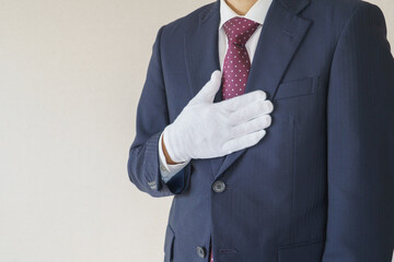 安心・おまかせポーズ｜スーツ姿で胸に手を当てる男性