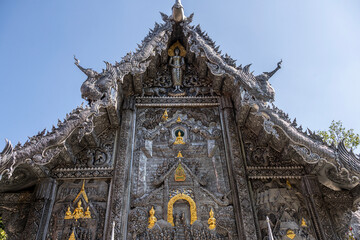 Separate fragments of a decorated Buddhist temple in Thailand on a sunny day
