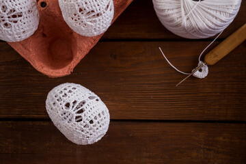 vertical Easter background, crochet Easter eggs, handmade decoration, white lace eggs, rustic wooden table, egg carton, spring holiday, farmhouse decor, country style, slow living, cozy atmosphere, ho