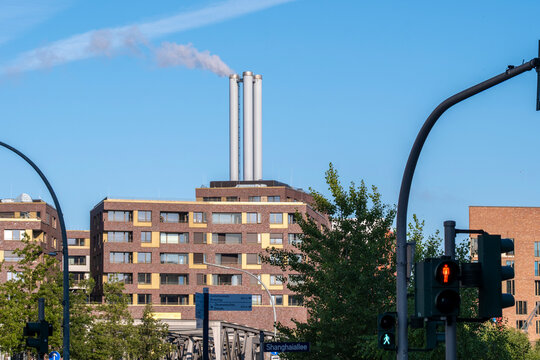 Urban apartments below sky with chimneys and smoke show Hamburg Germany industry energy and pollution themes for environmental documentary backdrop