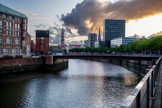 Modern waterfront skyline in Hamburg Germany with river reflections at sunset as clouds and smoke add dramatic atmosphere to city view