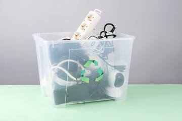 Recycle bin with different household appliances on green background