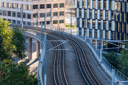 Modern city buildings frame a railway tracks junction on a viaduct showing urban infrastructure in Stockholm Sweden with layered rail corridors