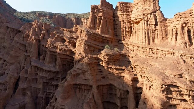 Aerial view captures awe-inspiring natural rock formations in arid Kyrgyzstan. Rugged Konorchek eroded sandstone canyons showing unreal intricacy of differential erosion.