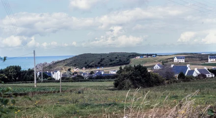 Gordijnen Kaki Erquy, Brittany, France, August 1982: rural coastal landscape with houses, fields and the sea in the background, everyday life and land use on the French coast in the early 1980s  © Bruno