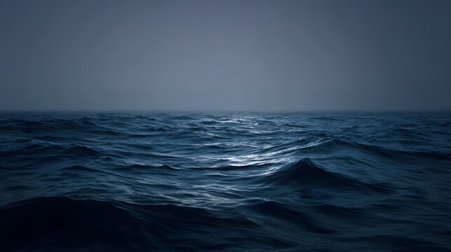 A vast dark choppy ocean under a hazy gray sky with subtle light reflections on the water surface