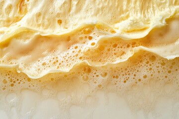 Obraz premium Close-up of a golden beer with a thick, creamy foam, set against a white background. High-resolution photography with insanely detailed and fine details This appears to be a professional stock photo
