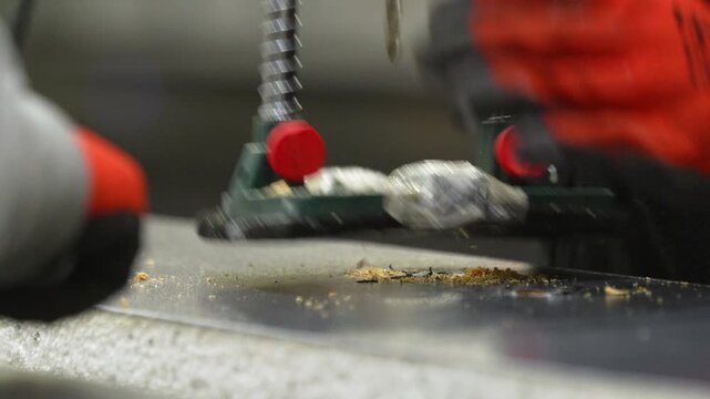 Close up of a professional drill press boring into a wooden board in a factory setting. Ideal for woodworking, manufacturing, and construction industry content.