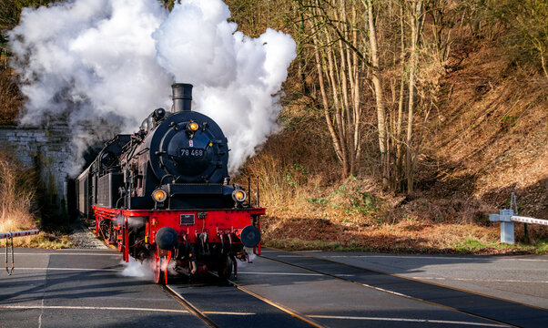 A steam train with a historic class 78 steam locomotive leaves the Schlossberg Tunnel in Arnsberg heading towards Meschede (Sauerland, Germany). Nostalgic railway trip in Ruhr valley.