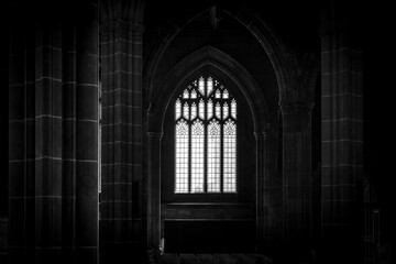 Obraz premium Gothic church window with stone columns in dark interior