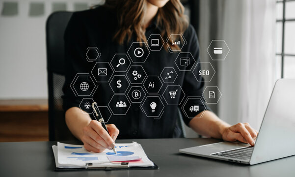 Businesswoman using smartphone and laptop with SEO, AI and analytics icons. Digital marketing strategy, fintech, data analysis