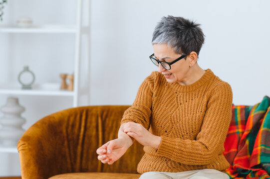 Senior woman scratching arm having skin allergy reaction
