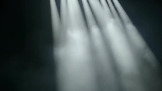 Beams of light cut through atmospheric haze, creating ethereal, diagonal streaks