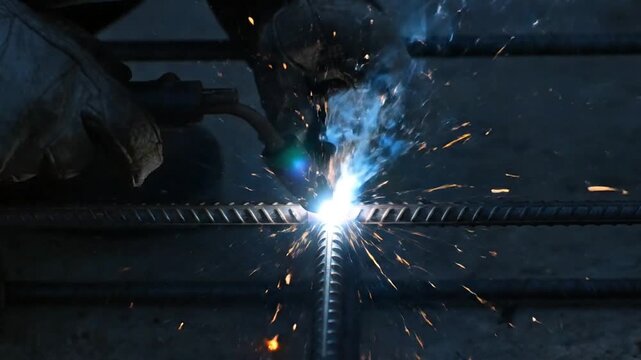 Close up of welder's hands with protective gloves creating sparks while welding metal Full HD 4k Video
