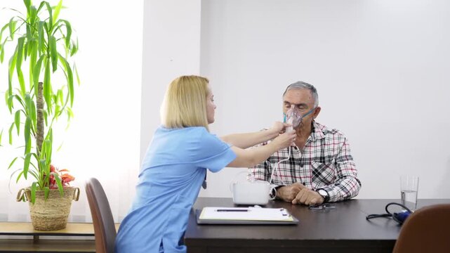 Medical professional assisting elderly man with breathing treatment