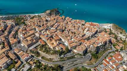 Panoramic aerial view of the historic center of Tropea, in province of Vibo Valentia, Calabria, southern Italy. The town is perched on a cliff overlooking the Mediterranean sea. Italian cityscape.