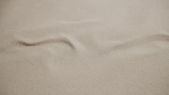 subtle tan sand with miniature hills and a shallow depth of field