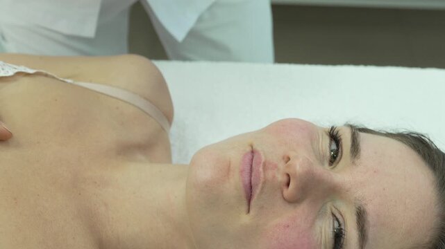 Filler injection cosmetology, specialist removes gauze from woman after successful lip augmentation procedure in modern beauty clinic.