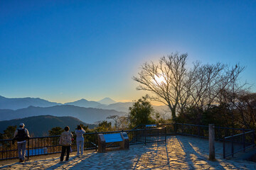 東京都八王子市の高尾山頂(大見晴園地)からの夕景(富士山,山並み,夕陽,観光客など）