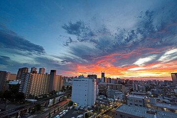 雲の隙間から見える夕焼けとビル群