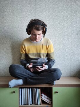 Focused teen gamer with smartphone sitting in lotus pose, digital addiction and youth lifestyle concept., Modern Education , Podcasting, focus on digital mental health and youth lifestyle.